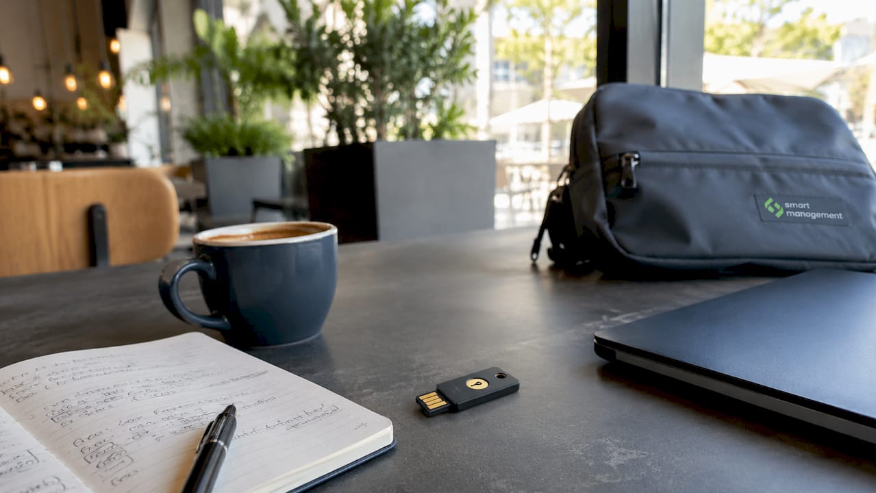 1783658360420_YubiKey-hardware-token-on-a-desk-with-cybersecurity-papers Ένας YubiKey βρίσκεται πάνω στο γραφείο, δίπλα σε έγγραφα που σχετίζονται με την ασφάλεια στον κυβερνοχώρο.